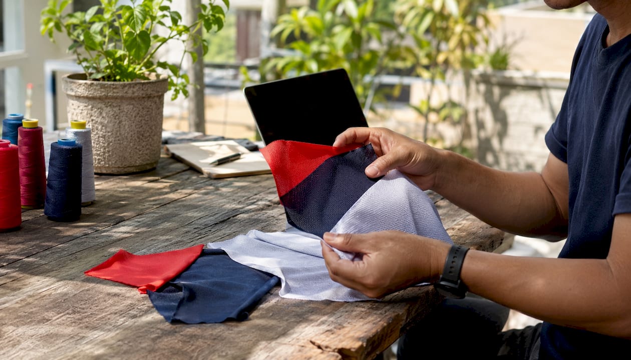 Hands selecting t-shirt fabrics for cycling events