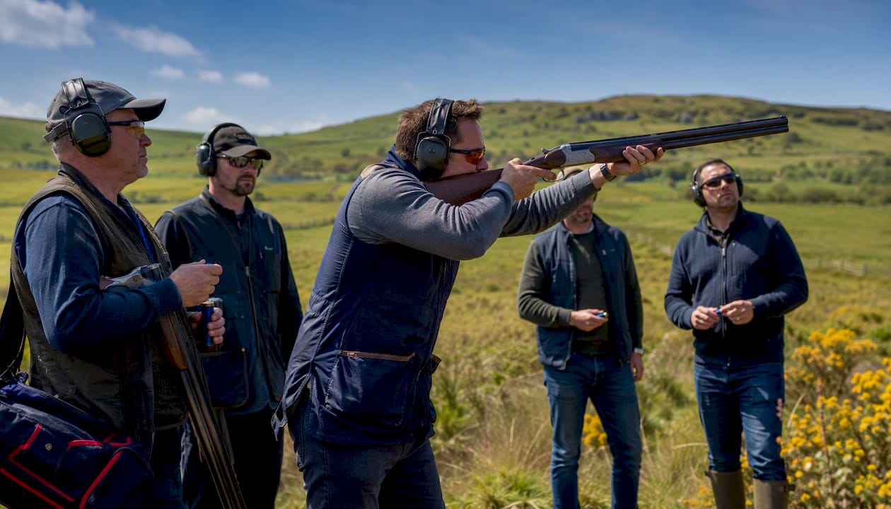 Men engaged in clay pigeon shooting activity