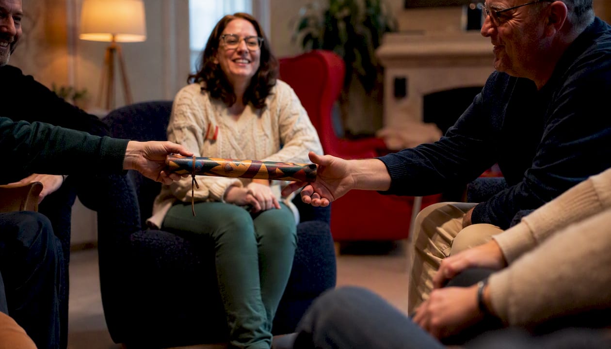 Hands passing talking stick in small group icebreaker