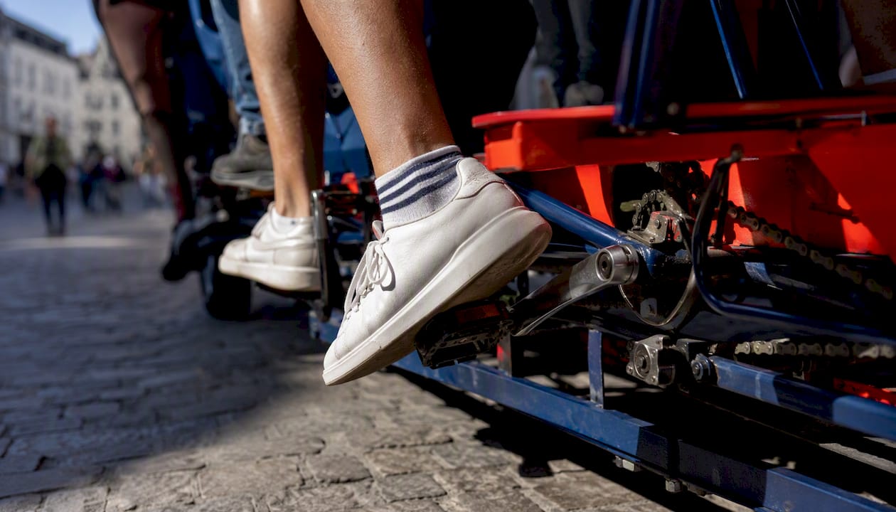 Close-up of feet pedaling party bike drivetrain