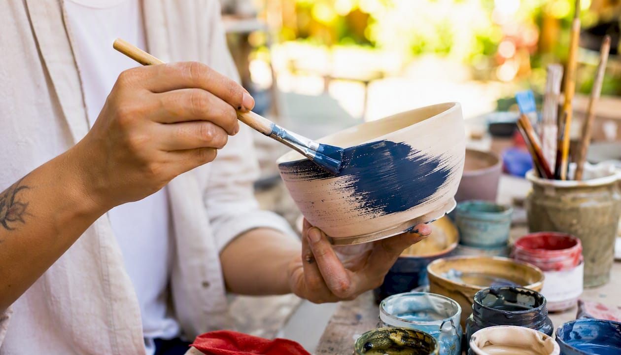 Hands glazing pottery bowl