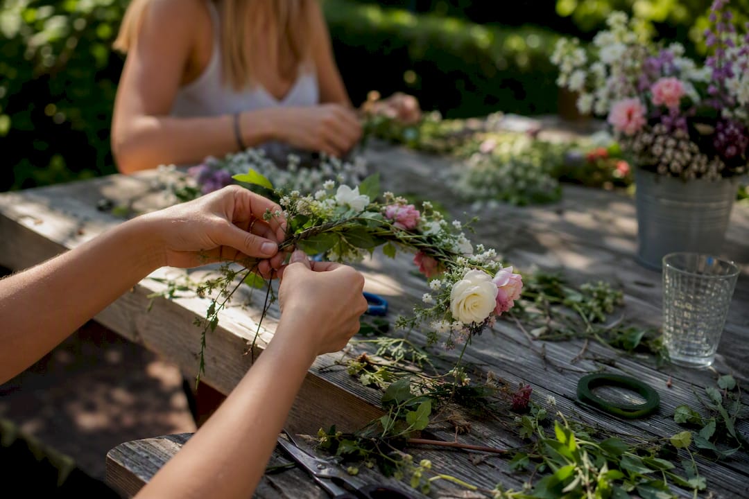 Hands making flower crowns at hen party