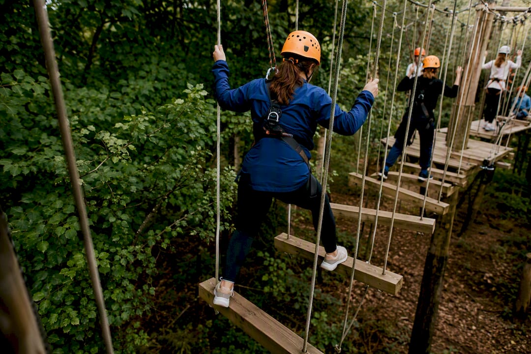 Participant crossing high ropes obstacle at adventure park