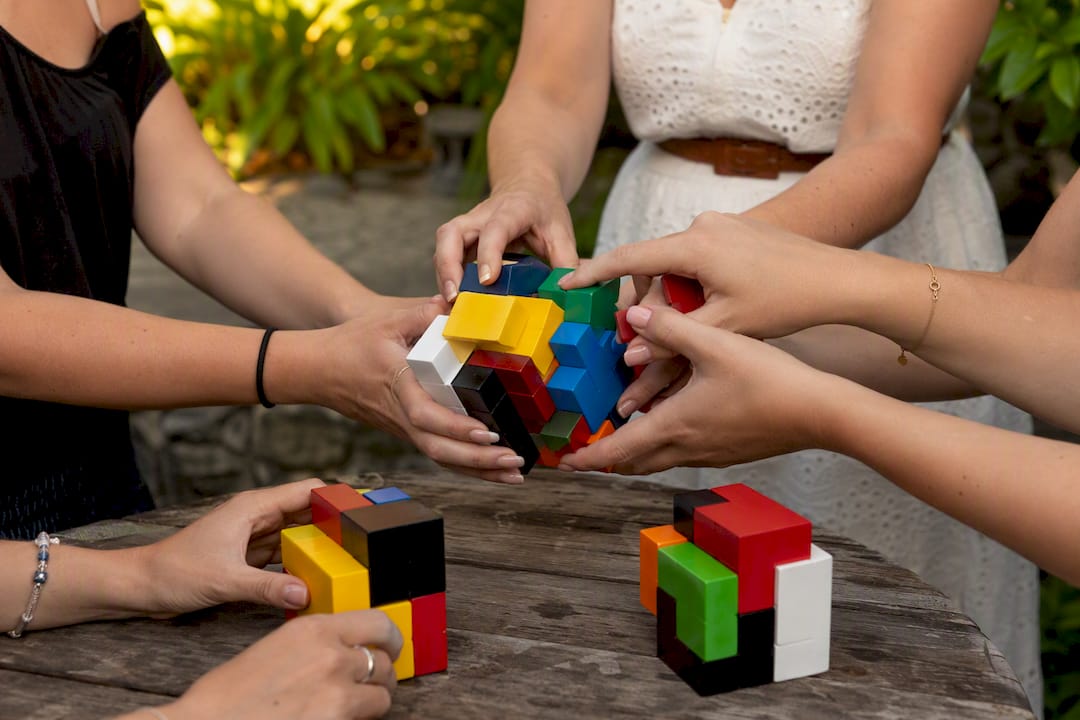 Close-up of hands passing puzzle cubes at hen party
