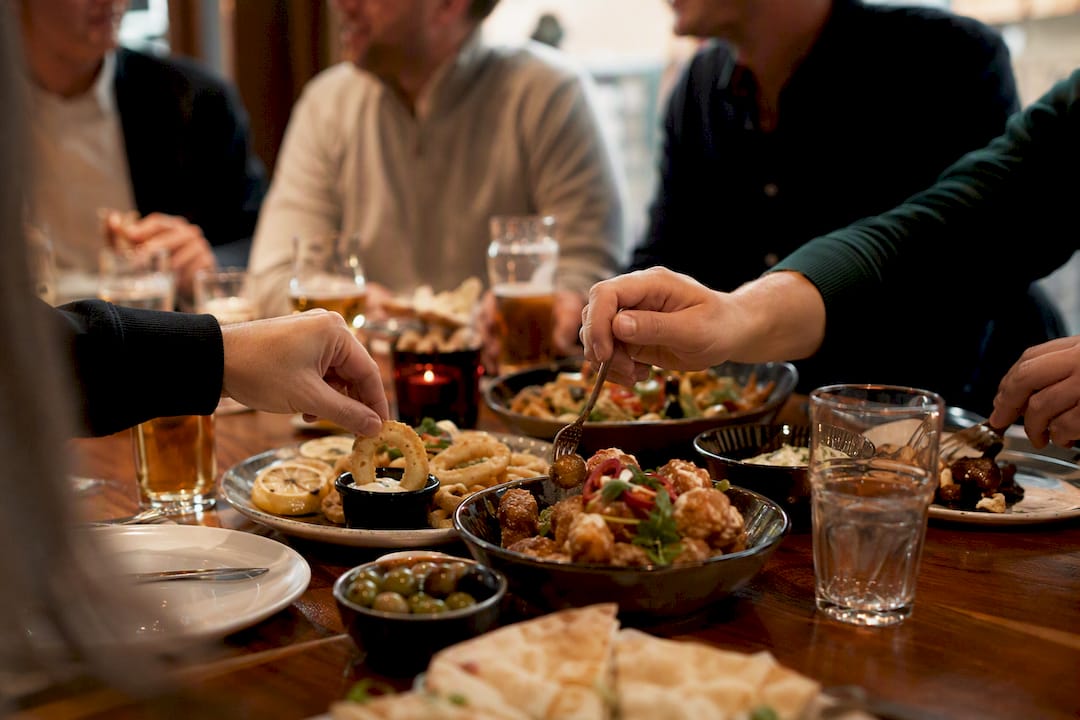 Hands passing plates at stag do pre-event dinner
