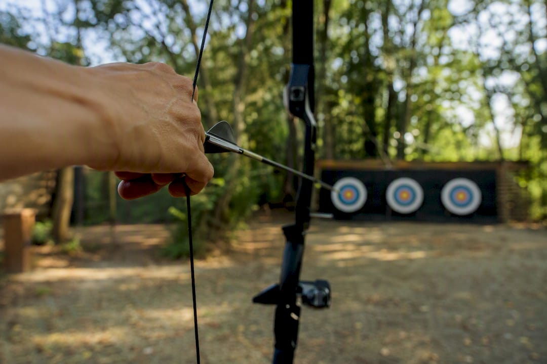 Hand drawing bowstring at archery range