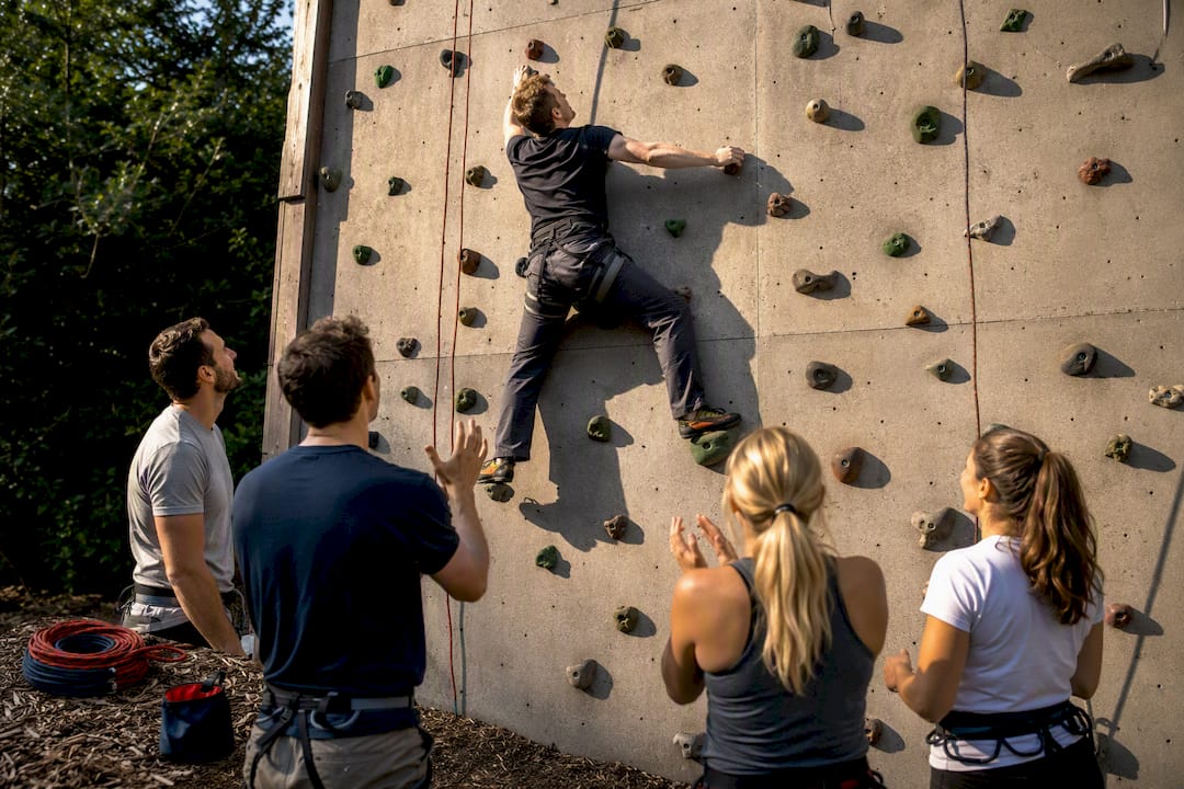 Team member climbing an outdoor adventure wall