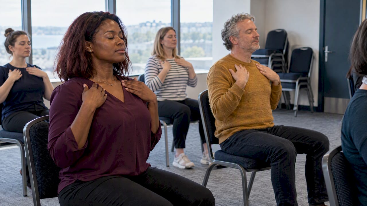 Staff doing seated mindfulness in a meeting room