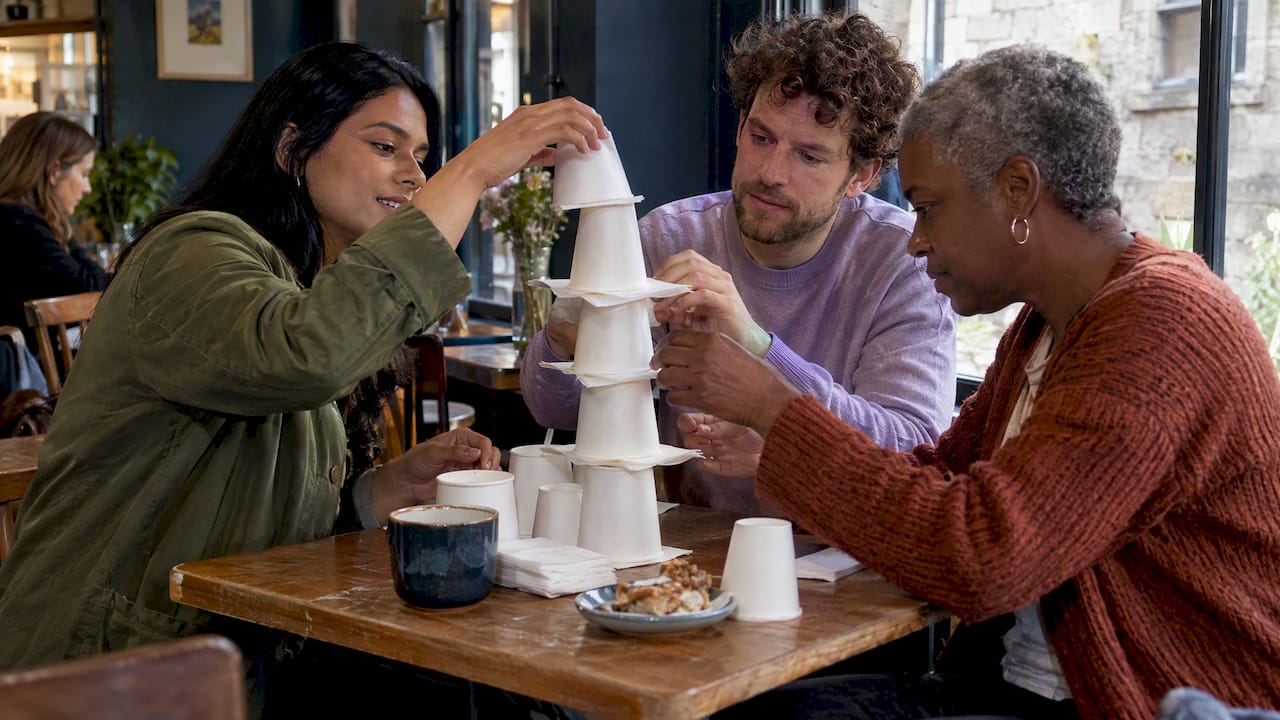 Friends build a cup and napkin tower